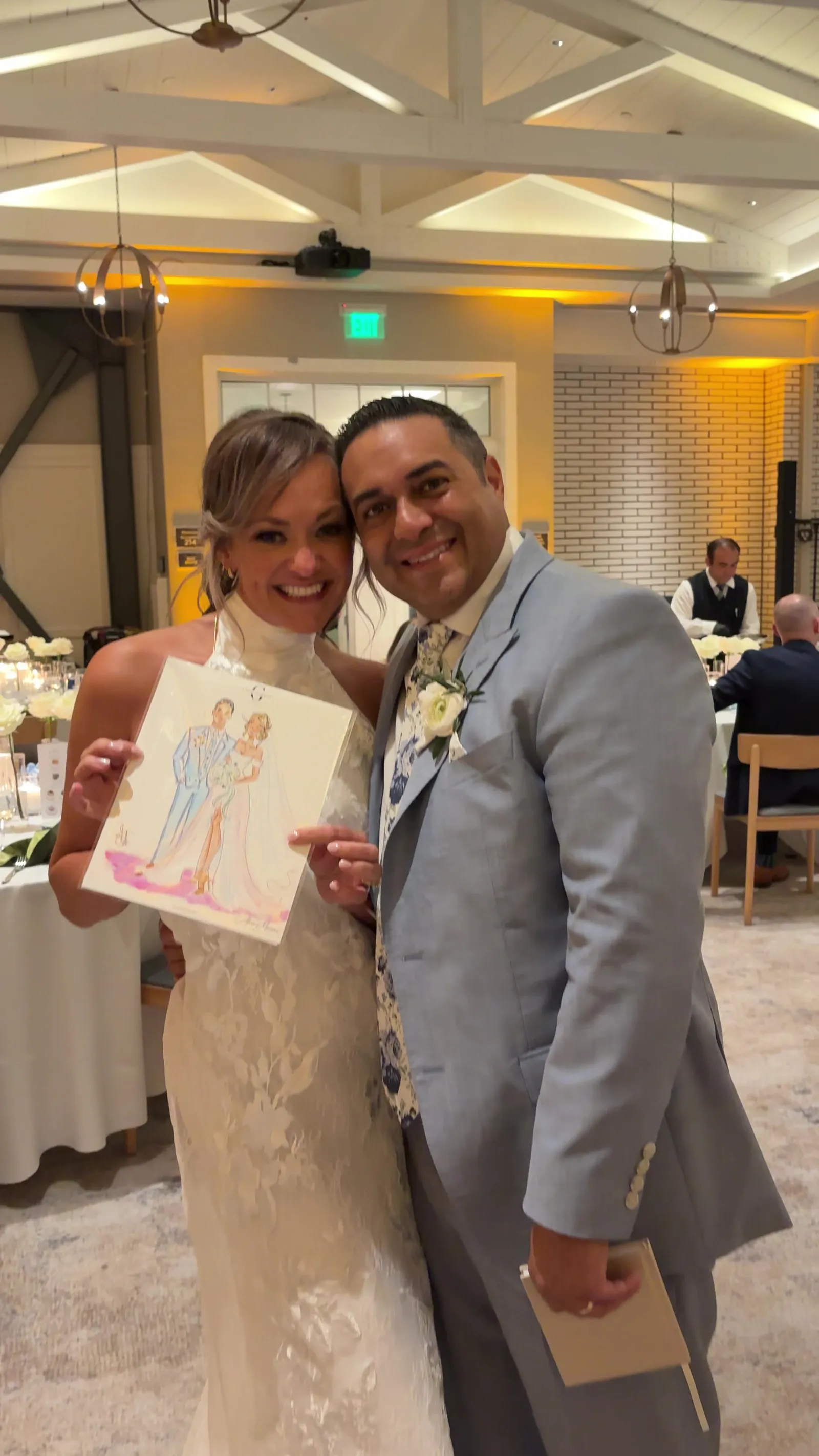 A bride and groom holding their sketch