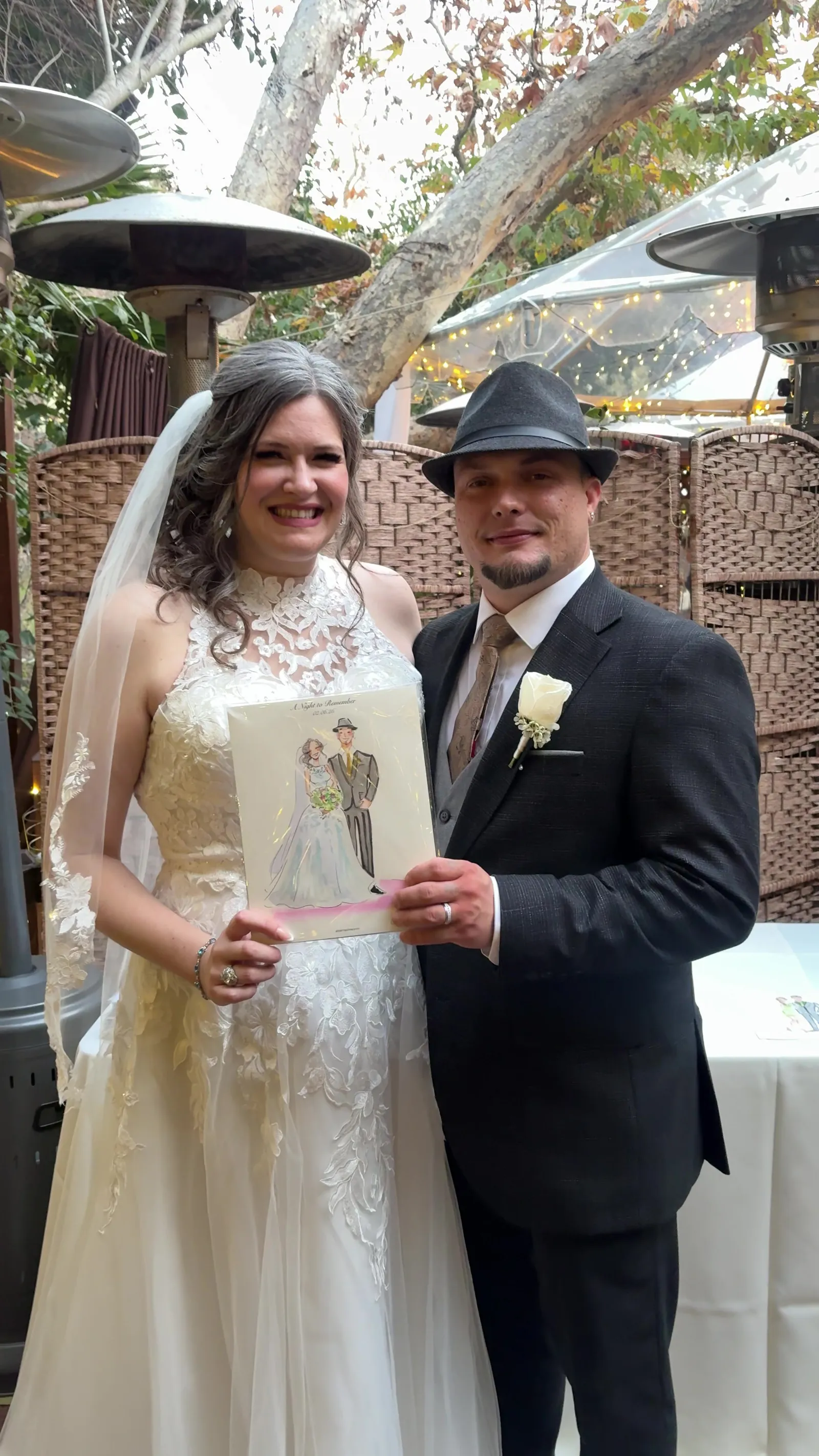 A bride and groom holding their sketch