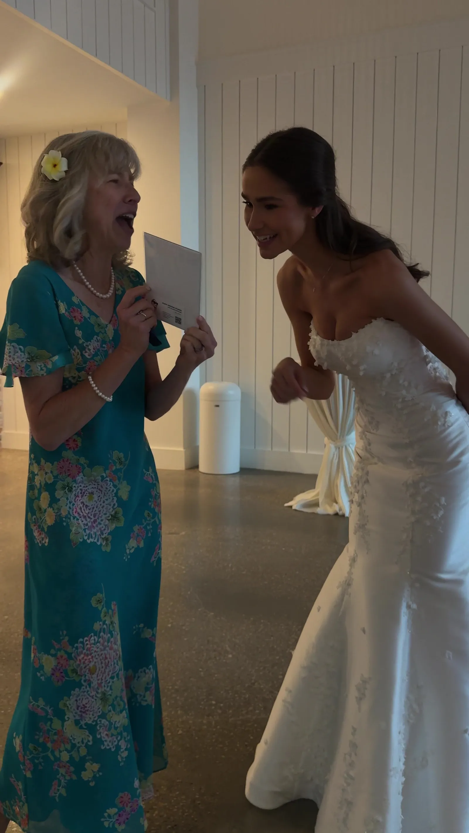 A bride laughing with a guest over a sketch