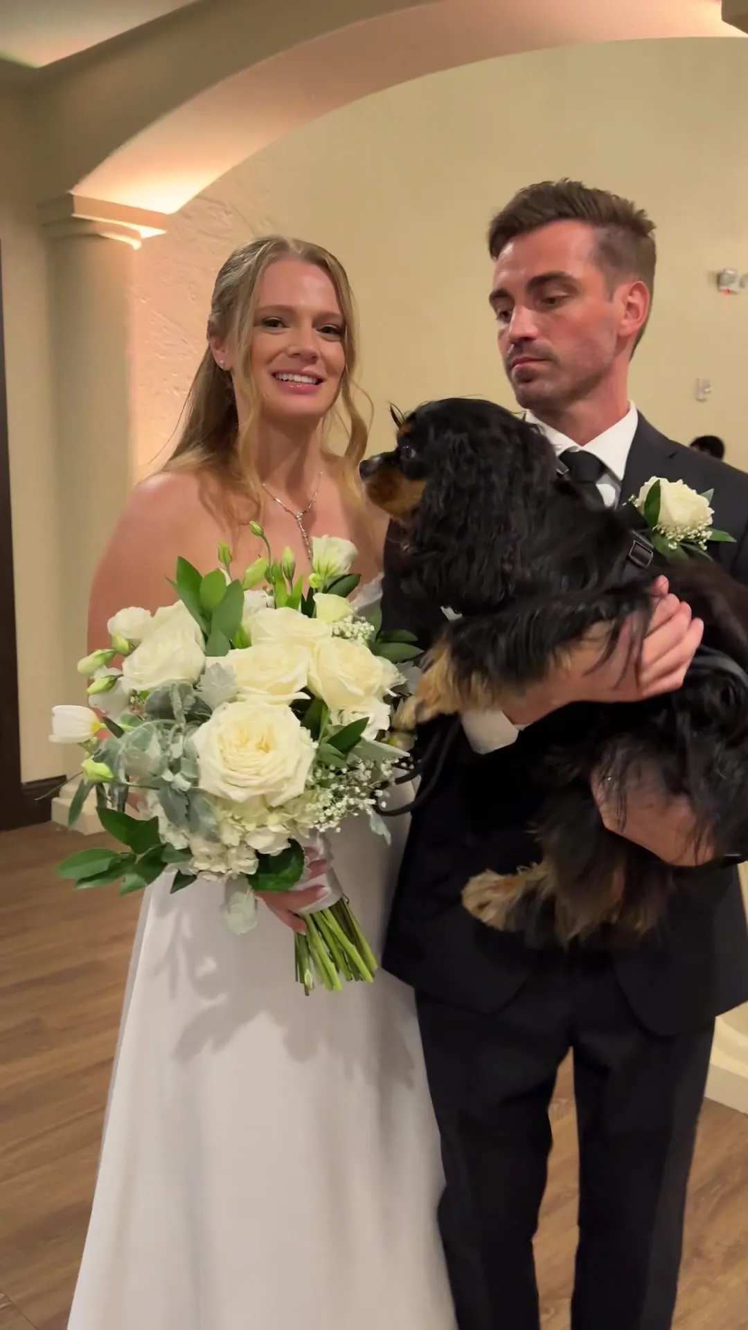 A bride and groom with their dog and the sketch